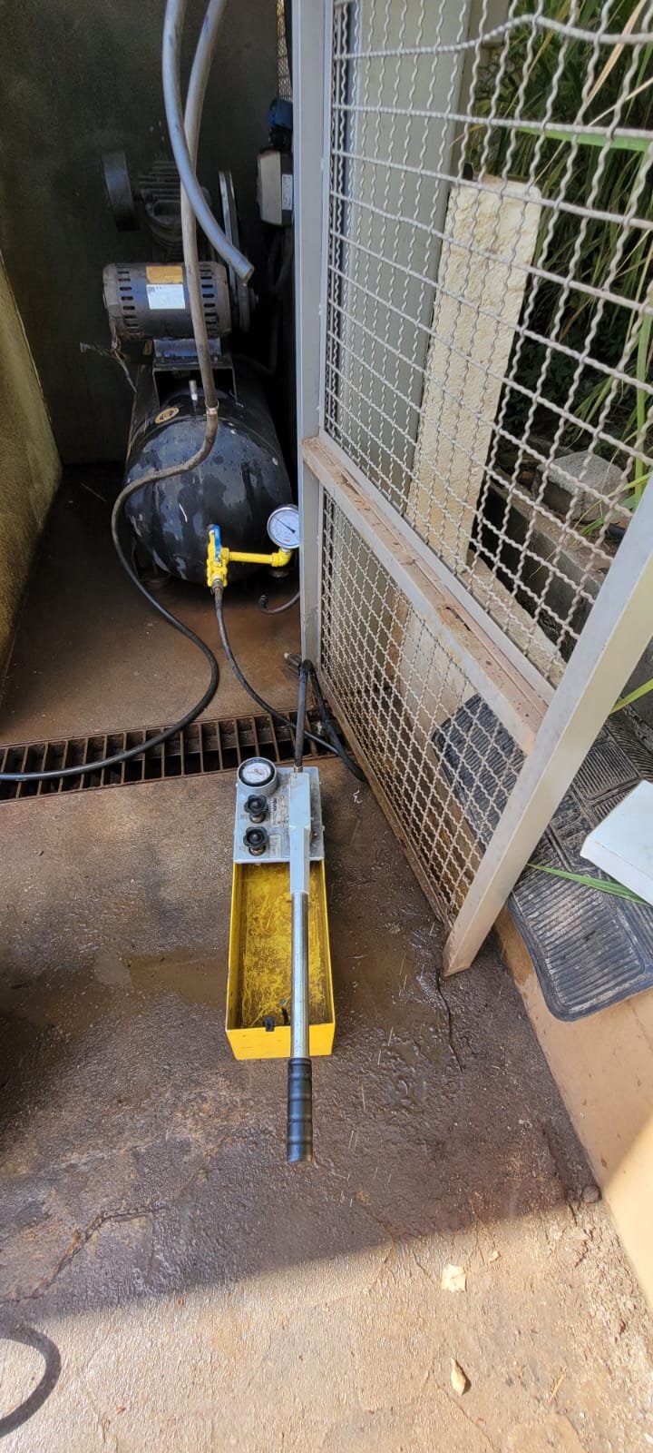 Bomba hidrostática amarela e compressor industrial dispostos para ensaio