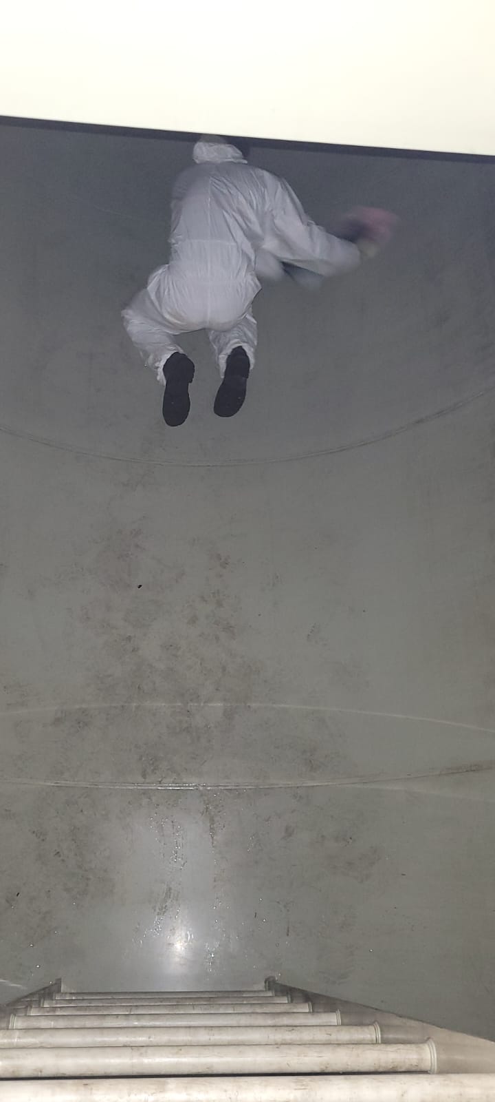 Profissional no interior de tanque durante limpeza interna